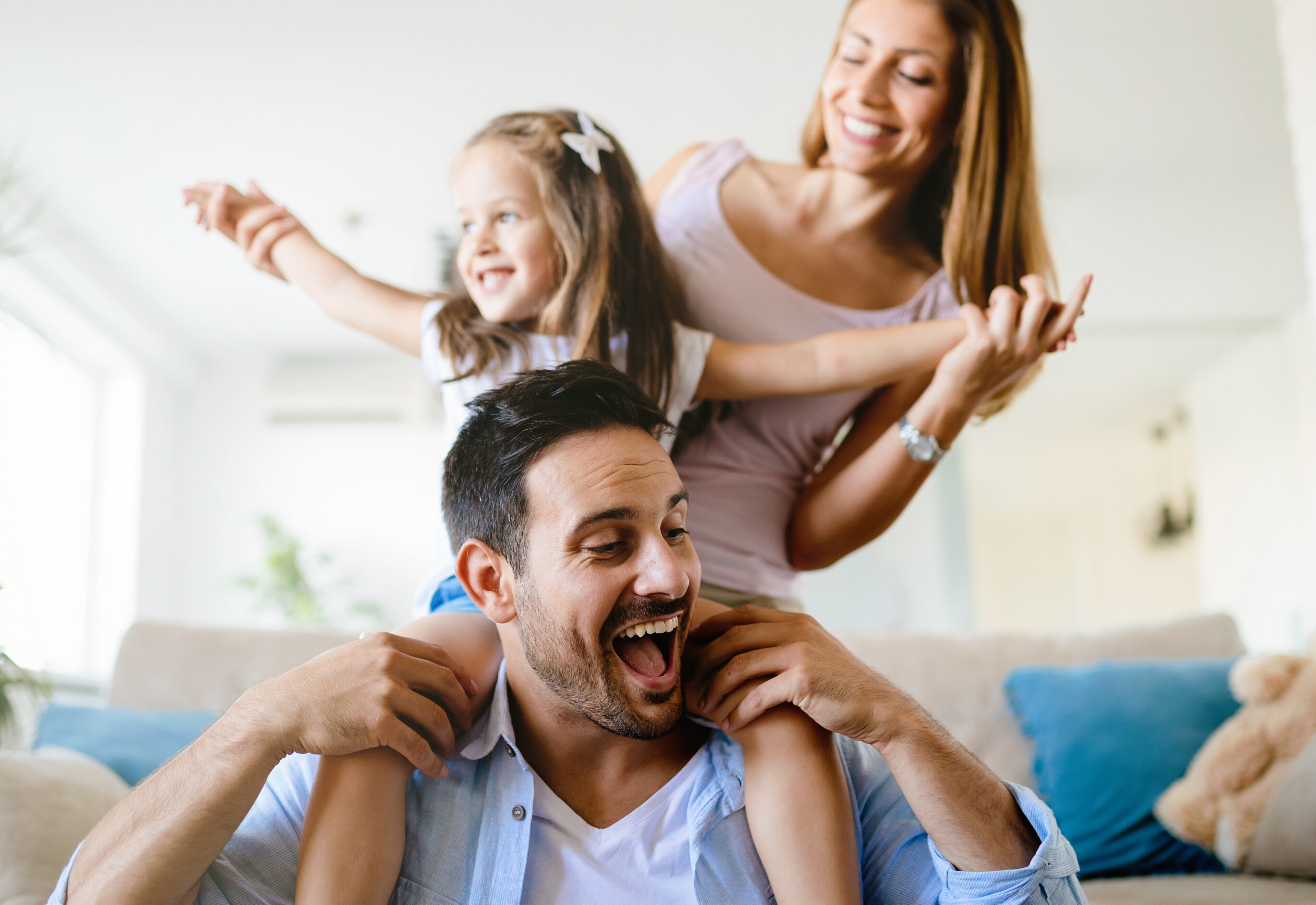Familie auf dem Sofa in einem angenehm gekühlten Wohnraum