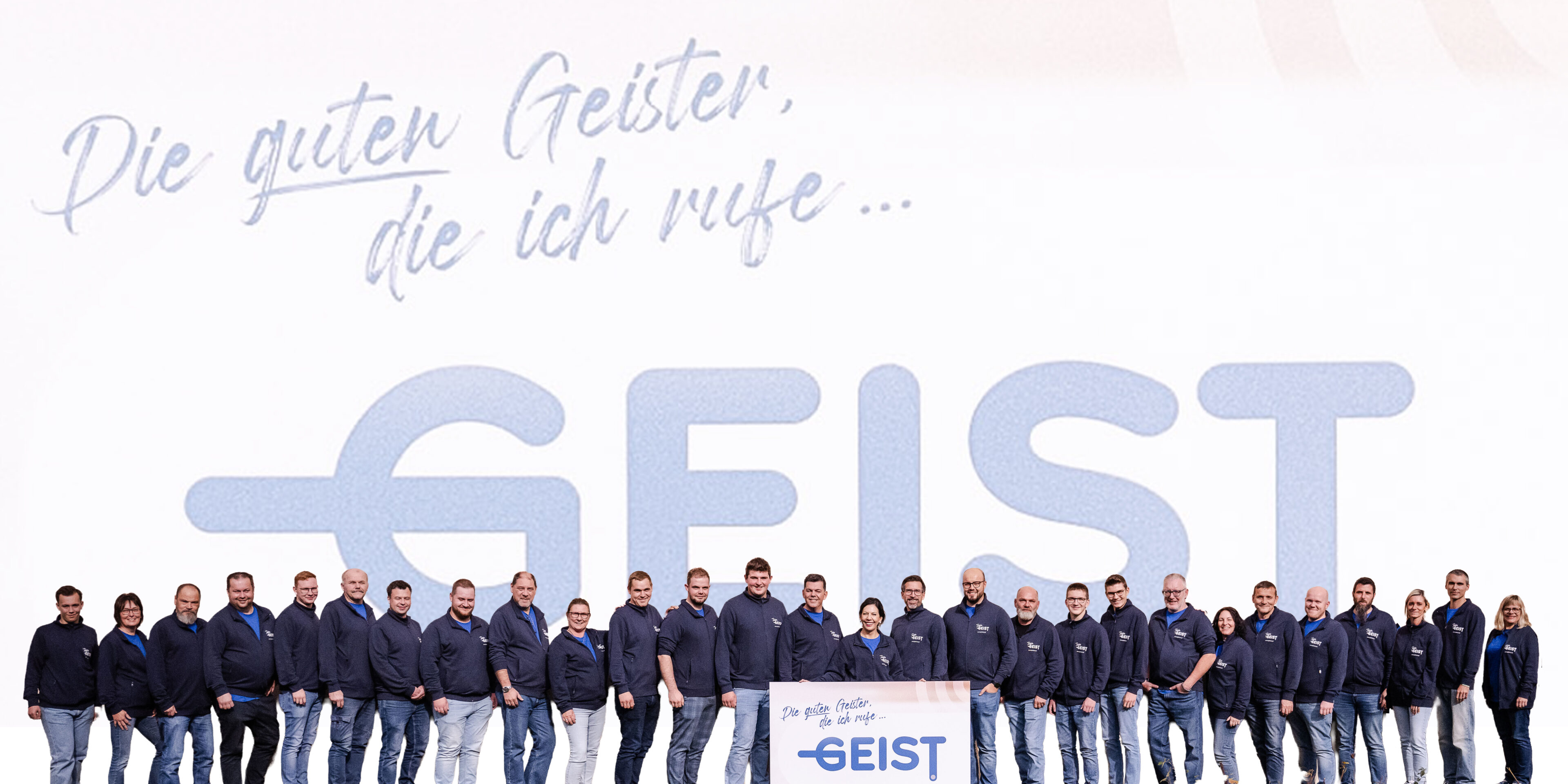 Das GEIST-Team vor dem Firmenschriftzug